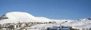 una montagna innevata con una stazione sciistica e una città di Résidence Phoenix B by Leavetown Vacations a LʼAlpe-dʼHuez Altre 6 foto