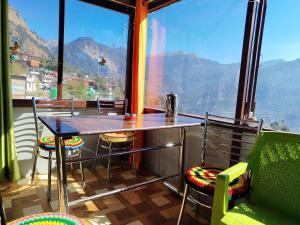 uma mesa e cadeiras em uma sala com uma grande janela em Ganesh home stay em Ukhimath mais 20 fotografias