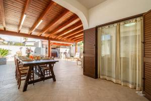 ein Esszimmer mit einem Tisch und einer Terrasse in der Unterkunft Villa DellOmbra in Alcamo + 24 Fotos