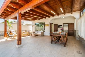 eine Außenterrasse mit einer Holzdecke und einem Tisch in der Unterkunft Villa DellOmbra in Alcamo