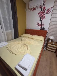 Beachfront Central Apartments في دوريس: سرير عليه بطانيه وفوطه +صورة واحدة