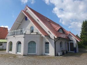 ein Gebäude mit einem roten Dach in der Unterkunft Villa Luba in Ostseebad Koserow