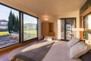 a bedroom with a large bed with a large window at Villa Monasterio in Escobedo