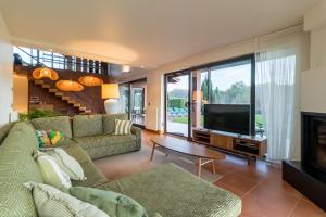 a living room with a couch and a television at Villa Monasterio in Escobedo