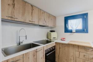 Villino Elvira في كوستوناتشي: مطبخ مع خزائن خشبية ومغسلة ونافذة