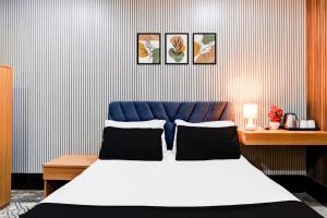 ein Schlafzimmer mit einem Bett und drei Bildern an der Wand in der Unterkunft Hotel O Nepali Mandir Bus Terminal Formerly Hotel Aaghnya in Guwahati + 27 Fotos