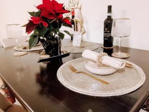 a table with red flowers and a bottle of wine at Harmony Private Single Room Freiburg in Freiburg im Breisgau