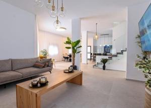 salon z kanapą i stołem w obiekcie אחוזת סנטוריני - וילה מהממת עם בריכה מחוממת מקורה וג'קוזי בעין יעקב w mieście ‘Ein Ya‘aqov