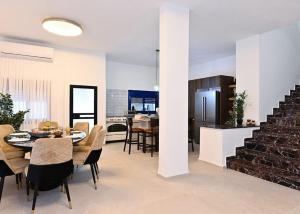 kuchnia i jadalnia ze stołem i krzesłami w obiekcie אחוזת סנטוריני - וילה מהממת עם בריכה מחוממת מקורה וג'קוזי בעין יעקב w mieście ‘Ein Ya‘aqov +9 zdjęć