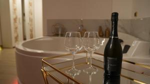 a bottle of wine and two wine glasses on a tray at Monte d'Oro Rooms in Scauri