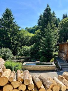 a garden with a stone wall and trees at Gîte le Frêne 