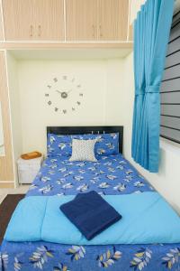 a bedroom with a blue bed with a clock on the wall at Casa61 Homestay in Bengaluru