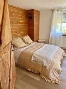 Un dormitorio con una cama grande con cabecero de madera. en Gîte le Frêne, 