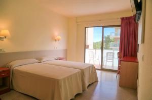 a hotel room with two beds and a balcony at htop Molinos Park - Fun in Salou