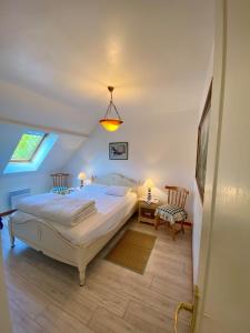 a bedroom with a large bed and two chairs at Au Petit Bonheur in Cucq
