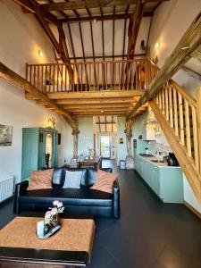 un soggiorno con un divano e un tavolo di Erfgoed & Logies Den Heijkant a Moergestel