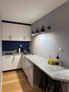 a kitchen with white cabinets and a counter with a bowl of fruit at Apartamenty Dąbrówka Cieplice Zdrój 1,15 in Jelenia Góra