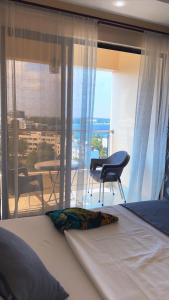 ein Schlafzimmer mit Bett und Blick auf einen Balkon in der Unterkunft 3rd Avenue Beach Apartments 3bedroom plus DSQ in Nyali in Mombasa