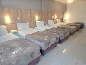 a row of beds lined up in a room at Hotel Rieger in Balneário Camboriú