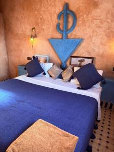 梅尔祖卡Riad camels house的卧室里有一张大床，上面铺着蓝色毯子