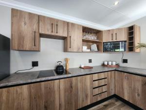 a kitchen with wooden cabinets and a counter top at Maison De Blom in Aliwal North