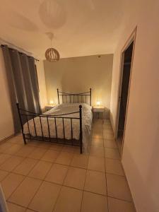 ein Schlafzimmer mit einem Bett und einem gefliesten Boden in der Unterkunft Appartement cosy au cœur de la vallée de la Marne in Mézy-Moulins