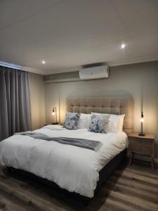 a bedroom with a large bed with two pillows at Maison De Blom in Aliwal North