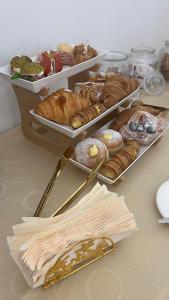 ein Tisch mit mehreren Tabletts mit verschiedenen Gebäcksorten in der Unterkunft Duomo Room Comacchio in Comacchio