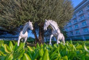 Eine Statue von zwei Pferden vor einem Baum in der Unterkunft Innvista Hotels Belek in Belek