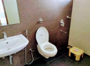 a bathroom with a white toilet and a sink at Sri Durga Residency in Subrahmanya