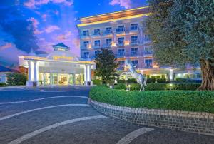 ein Hotel mit einer Giraffenstatue vor einem Gebäude in der Unterkunft Innvista Hotels Belek in Belek