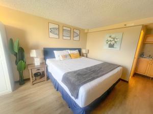 una camera da letto con un letto grande in una stanza di Happy Hawaiian Monarch Studio condo a Honolulu Altre 18 foto