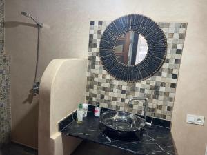 um banheiro com pia e espelho em Riad Eglantine em Touggana mais 1 fotografia