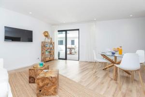 a white living room with a table and white chairs at New 2bedroom Apartment w Terrace & Infinity Pool in Olhos de Água
