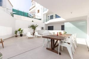 a dining room with a wooden table and white chairs at New 2bedroom Apartment w Terrace & Infinity Pool in Olhos de Água