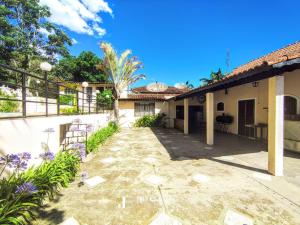 um pátio fora de uma casa com flores roxas em Chácara c/ Piscina, Churrasqueira com vista linda em Poços de Caldas