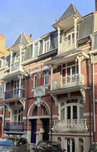 a large brick building with balconies on a street at Villa Seven 2 in Dunkerque