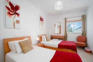 una camera d'albergo con due letti e una finestra di Apartment Rosetta, Formosa Village a Fuzeta Altre 29 foto