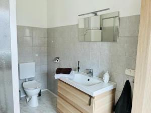 ein Badezimmer mit einem weißen Waschbecken und einer Toilette in der Unterkunft Zimmer in Werneuchen bei Berlin in Werneuchen