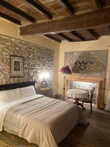 una camera da letto con un letto grande e un muro di pietra di BORGO VILLA VALENTINI a Scandiano