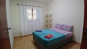 mała sypialnia z łóżkiem i oknem w obiekcie Casa em São Francisco Xavier/sp w mieście São Francisco Xavier