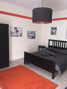 ein Schlafzimmer mit einem schwarzen Bett und einem roten Teppich in der Unterkunft B&B Napoli Napoli in Neapel