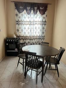 KartungGeorgianas Residence的一间有桌子、椅子和窗户的餐厅