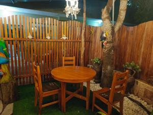 een houten tafel en stoelen voor een hek bij Tesita's House habitación doble in Puerto Baquerizo Moreno