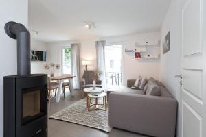 a living room with a couch and a fireplace at Apartment unter den Kiefern 93 in Röbel