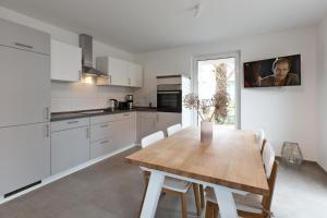 a kitchen with a wooden table and white cabinets at Apartment unter den Kiefern 93 in Röbel