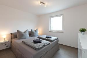 a bedroom with a bed with two pillows on it at Apartment unter den Kiefern 93 in Röbel