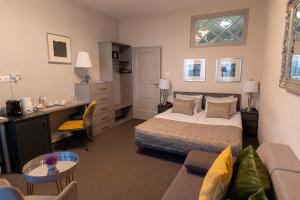 a bedroom with a bed and a desk and a couch at Hotel Piano in Szeged +45 photos