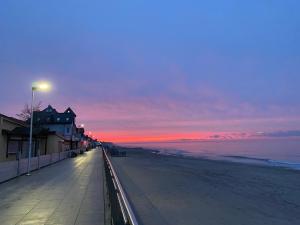 a view of a beach at sunset with a street light at KORALIA Domki StandardPlus JACUZZI na wyłączność, BASEN in Sarbinowo