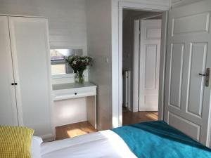 a bedroom with a bed and a vase of flowers on a table at KORALIA Domki StandardPlus JACUZZI na wyłączność, BASEN in Sarbinowo